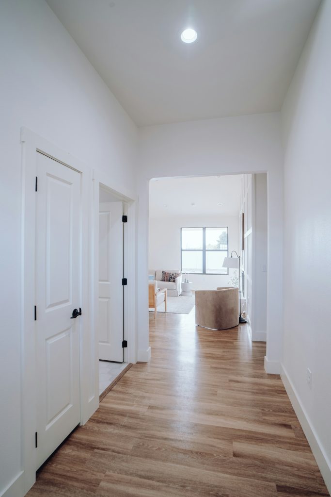 an empty room with white walls and wood floors